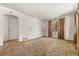 Spacious living room featuring neutral walls, carpet, and a window with brown curtains, bathed in natural light at 1665 S Madison St, Denver, CO 80210