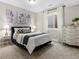 Comfortable bedroom featuring a large window, neutral colored walls and carpet, and a stylish dark blue bedframe at 5511 Wabash St, Denver, CO 80238