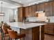 Modern kitchen showcasing a large island with seating and stylish backsplash and wooden cabinetry at 5511 Wabash St, Denver, CO 80238