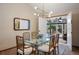 Dining room with glass-top table and bamboo chairs, adjacent to a sunroom at 3420 S Nucla Way, Aurora, CO 80013