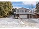 Two-story house with attached garage and deck, nestled in a snowy landscape at 3420 S Nucla Way, Aurora, CO 80013