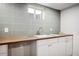 Basement wet bar with wood countertop and white cabinets at 991 S Holly St, Denver, CO 80246