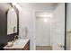 Basement bathroom with modern vanity and arched mirror at 991 S Holly St, Denver, CO 80246