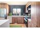 Modern kitchen with dark herringbone tile and wood cabinets at 991 S Holly St, Denver, CO 80246