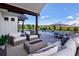 Entertain in this backyard paradise with a covered patio, fire pit, dining and lounge area, and sparkling pool at 2705 Fox View Trl, Franktown, CO 80116