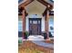 Charming front entrance with beautiful dark wooden columns, an elegant door, and potted plants at 2705 Fox View Trl, Franktown, CO 80116