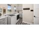 Well-organized laundry room featuring gray cabinets, stylish tile flooring, and modern washer and dryer at 2705 Fox View Trl, Franktown, CO 80116