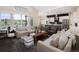 Open-concept living space with modern furnishings and large windows overlooking the backyard at 2705 Fox View Trl, Franktown, CO 80116