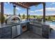 Outdoor kitchen with pizza oven and grill overlooking an in-ground pool at 2705 Fox View Trl, Franktown, CO 80116