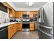 Well-equipped kitchen with wooden cabinetry, modern appliances, and hardwood flooring at 4604 Routt St, Wheat Ridge, CO 80033