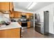Efficient kitchen featuring oak cabinets, stainless steel appliances, and hardwood floors at 4604 Routt St, Wheat Ridge, CO 80033