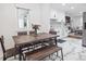 Bright dining area with a rustic wood table, bench seating, and a view to the modern kitchen at 3218 S Lafayette St, Englewood, CO 80113