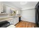 Bright kitchen with wood flooring, white cabinetry, black appliances, and backyard window view at 2078 S Quintero St, Aurora, CO 80013