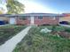 Charming one-story brick home with a walkway and flower beds at the front of the house at 106 Emerald St, Broomfield, CO 80020
