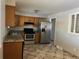 Kitchen with wood cabinets, granite counters, and stainless steel appliances at 3236 Carson St, Aurora, CO 80011