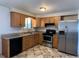 Kitchen with wood cabinets, granite counters, and stainless steel appliances at 3236 Carson St, Aurora, CO 80011