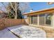 Snow-covered backyard with a sliding glass door, patio and wooden fence at 7318 W Cedar Cir, Lakewood, CO 80226