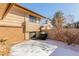 Snow-covered backyard with brick accents, a patio, and minimal winter foliage at 7318 W Cedar Cir, Lakewood, CO 80226