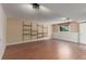 Finished basement space with wood laminate flooring and built-in shelving at 7318 W Cedar Cir, Lakewood, CO 80226