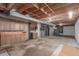 Unfinished basement with exposed wood ceiling, utility equipment, and a separate storage area at 7318 W Cedar Cir, Lakewood, CO 80226