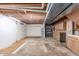 Unfinished basement with exposed wood ceiling, cabinets, and concrete walls at 7318 W Cedar Cir, Lakewood, CO 80226