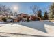 The home features a two-story structure with a two-car garage and an inviting, snowy front yard at 7318 W Cedar Cir, Lakewood, CO 80226