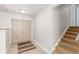 Inviting foyer with tile flooring, double front doors, adjacent carpeted stairs and neutral wall paint at 7318 W Cedar Cir, Lakewood, CO 80226