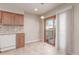 Kitchen area with sliding door to outside area, neutral tile floor and white window shade at 7318 W Cedar Cir, Lakewood, CO 80226