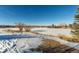 Winter view of a snow-covered lake surrounded by trees and foliage beneath a clear blue sky at 7318 W Cedar Cir, Lakewood, CO 80226