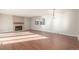 Bright, airy living room featuring hardwood floors, a cozy fireplace, and ample natural light at 7318 W Cedar Cir, Lakewood, CO 80226