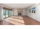 Sunlit living room with hardwood floors, fireplace, large sliding glass doors and bright windows at 7318 W Cedar Cir, Lakewood, CO 80226