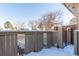 Snow-covered patio with a gate leading to outdoor area with beautiful trees at 7318 W Cedar Cir, Lakewood, CO 80226