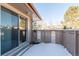 Snow-covered patio with sliding glass door and wooden fence, perfect for outdoor relaxation at 7318 W Cedar Cir, Lakewood, CO 80226