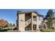 Two-story condo with stone accents and a well-maintained landscape for enhanced curb appeal at 10165 E Carolina Pl # 102, Aurora, CO 80247
