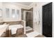 Bright bathroom featuring a soaking tub, glass shower, and neutral tile with white accents at 7777 E 23Rd Ave # 201, Denver, CO 80238