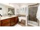 Beautiful bathroom featuring a double sink vanity, soaking tub, glass shower, and neutral tile at 7777 E 23Rd Ave # 201, Denver, CO 80238