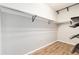 Walk-in closet featuring wood floors and rod and shelving system with black metal fixtures at 7777 E 23Rd Ave # 201, Denver, CO 80238
