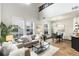 Bright living room with large windows, stylish decor, and seamless access to dining area and kitchen at 7777 E 23Rd Ave # 201, Denver, CO 80238