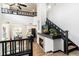 Open-concept living space with fireplace, modern staircase, and view of the kitchen and dining area at 7777 E 23Rd Ave # 201, Denver, CO 80238