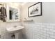 Elegant powder room featuring classic subway tile wainscoting, pedestal sink, and stylish accents at 7777 E 23Rd Ave # 201, Denver, CO 80238