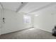 Clean basement with carpet flooring, bright window, and exposed beams at 10886 Bayfield Way, Parker, CO 80138