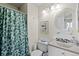 Well-lit bathroom with a vanity, round mirror, and shower with decorative curtain at 10886 Bayfield Way, Parker, CO 80138