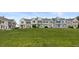 Exterior shot of townhomes on green space beneath a bright blue sky at 10886 Bayfield Way, Parker, CO 80138