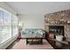 Inviting living room featuring a stone fireplace, hardwood floors, and large window at 10886 Bayfield Way, Parker, CO 80138