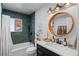 Updated bathroom with dark vanity, a large mirror, and green tile shower surround at 290 Pierce St, Lakewood, CO 80226