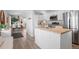Modern kitchen with white cabinets, wood countertops, and stainless steel appliances at 290 Pierce St, Lakewood, CO 80226