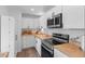 Modern kitchen featuring white cabinets, stainless steel appliances, and butcher block countertops at 290 Pierce St, Lakewood, CO 80226