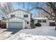 Two-story house with a green garage door and snowy front yard at 2527 S Coors St, Lakewood, CO 80228