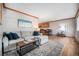 Living room with hardwood floors, a sectional sofa and open kitchen view at 2527 S Coors St, Lakewood, CO 80228