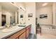 Bright bathroom with double sinks, wooden vanity, and a soaking tub at 4143 Da Vinci Dr, Longmont, CO 80503